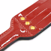 Red patent leather racket with gold rivets